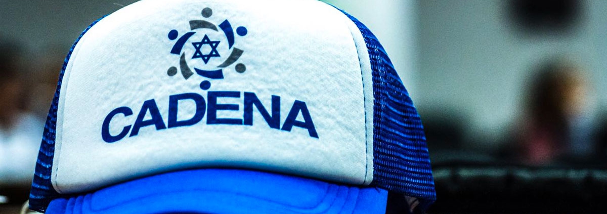 Una gorra azul y blanca, con el logotipo de CADENA al frente.