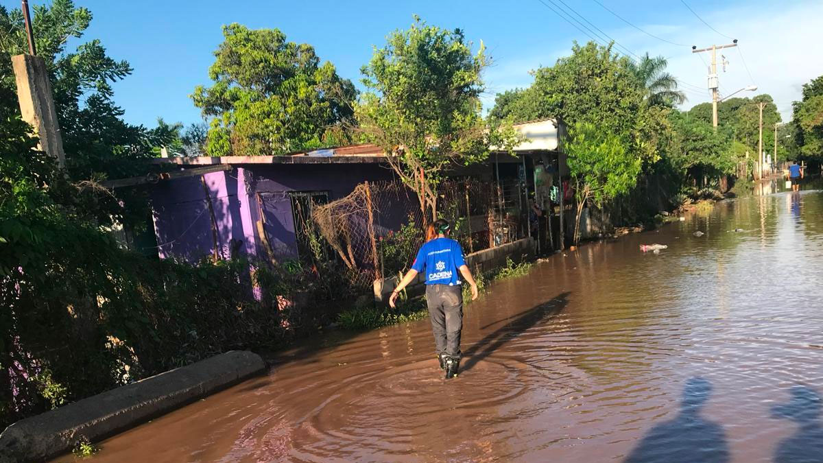 Un voluntario CADENA camina sobre la inundación en SInaloa
