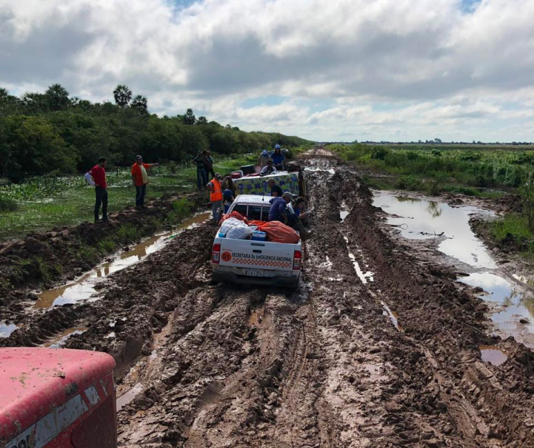 Pickups con el equipo de CADENA pasan por terreno lodoso rumbo a las comunidades afectadas.