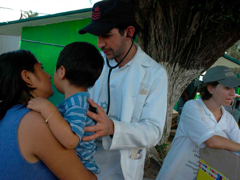 Un doctor voluntario de CADENA revisa a un niño en Tabasco