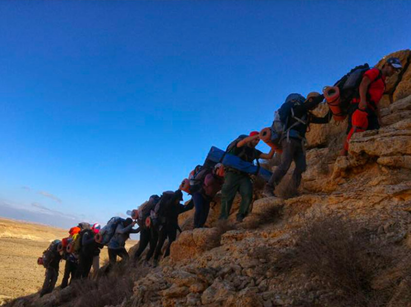 Participantes del curso de rescatista escalan una colina.