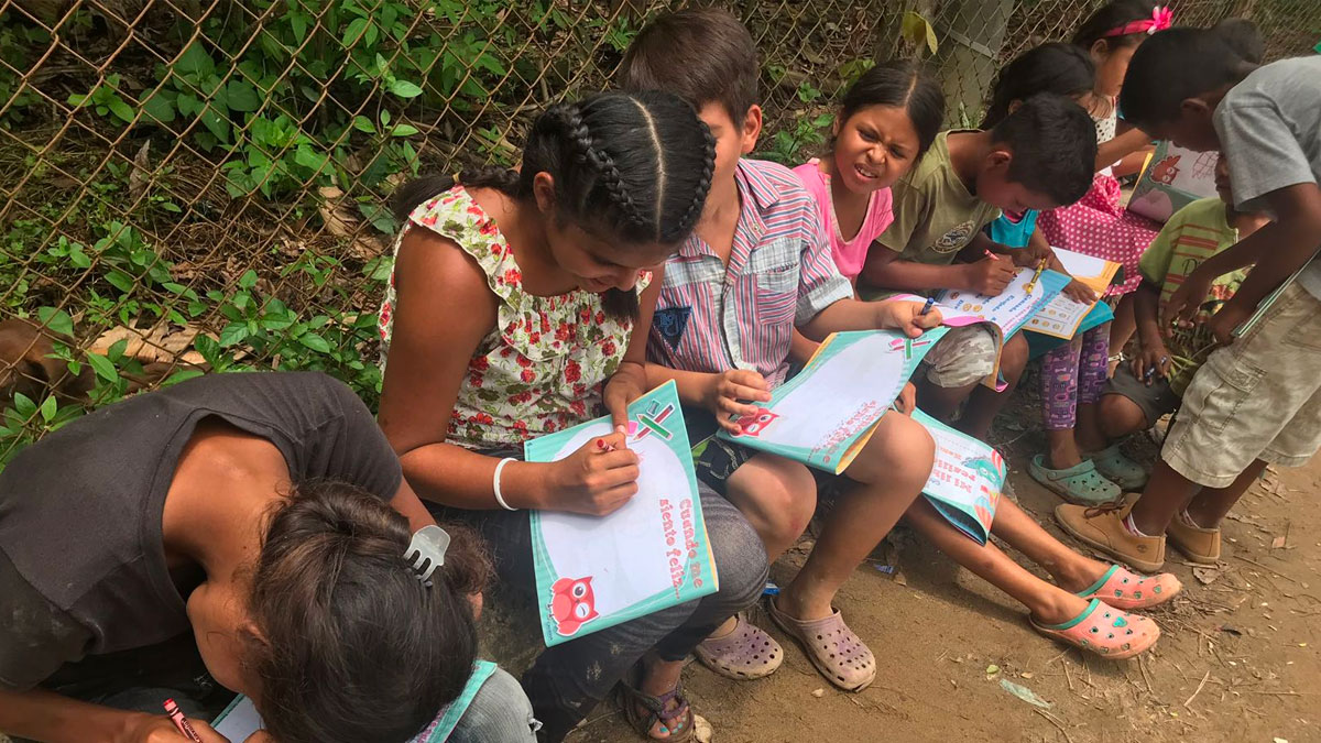 Children participate during a creative writing exercise during a CADENA mission.